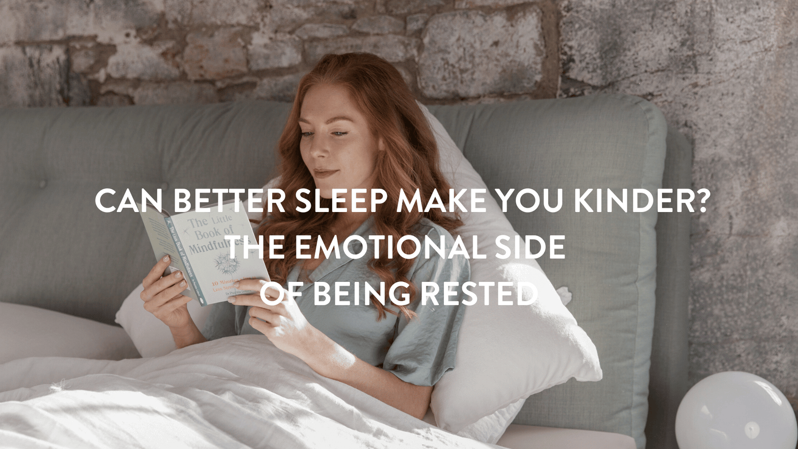 Person sitting up in bed reading the Little Book of Mindfulness