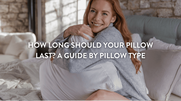 person sitting in bed hugging a putnams pillow 