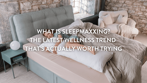 Person sleepmaxxing on a double bed surrounded by Putnams natural product collection