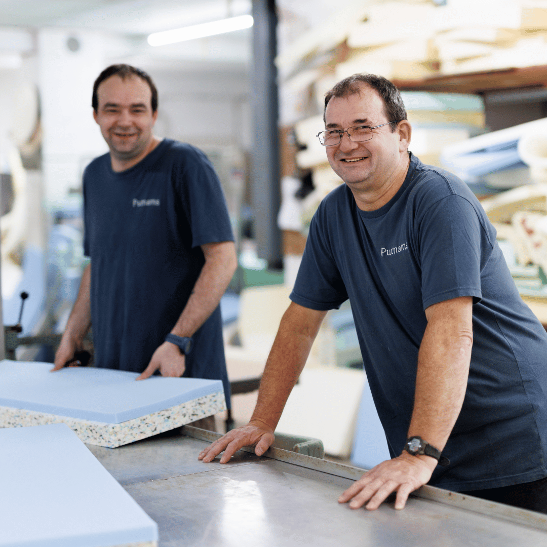 two foam cutters smiling at the camera wearing Putnams branded t-shirts